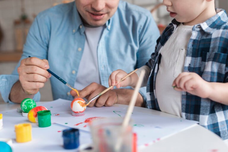 Toddler and dad work on arts and crafts together on chair and table rentals.