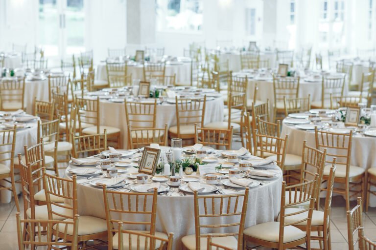 Round tables rentals with gold and white chair rentals and flatware.
